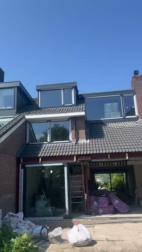Woning waar boven en beneden nieuwe kozijnen zijn geplaatst, gezien vanaf de achterzijde